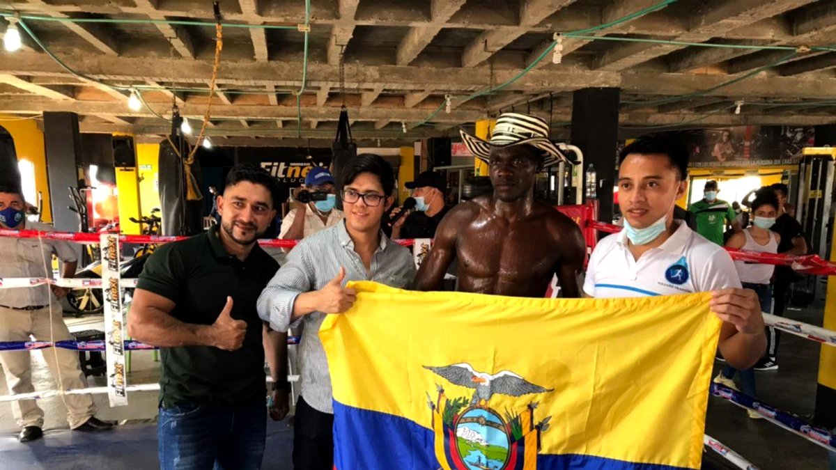 Abel Mina luce orgulloso la bandera tricolor tras vencer por KO técnico al colombiano Luis Hernán Rodríguez.