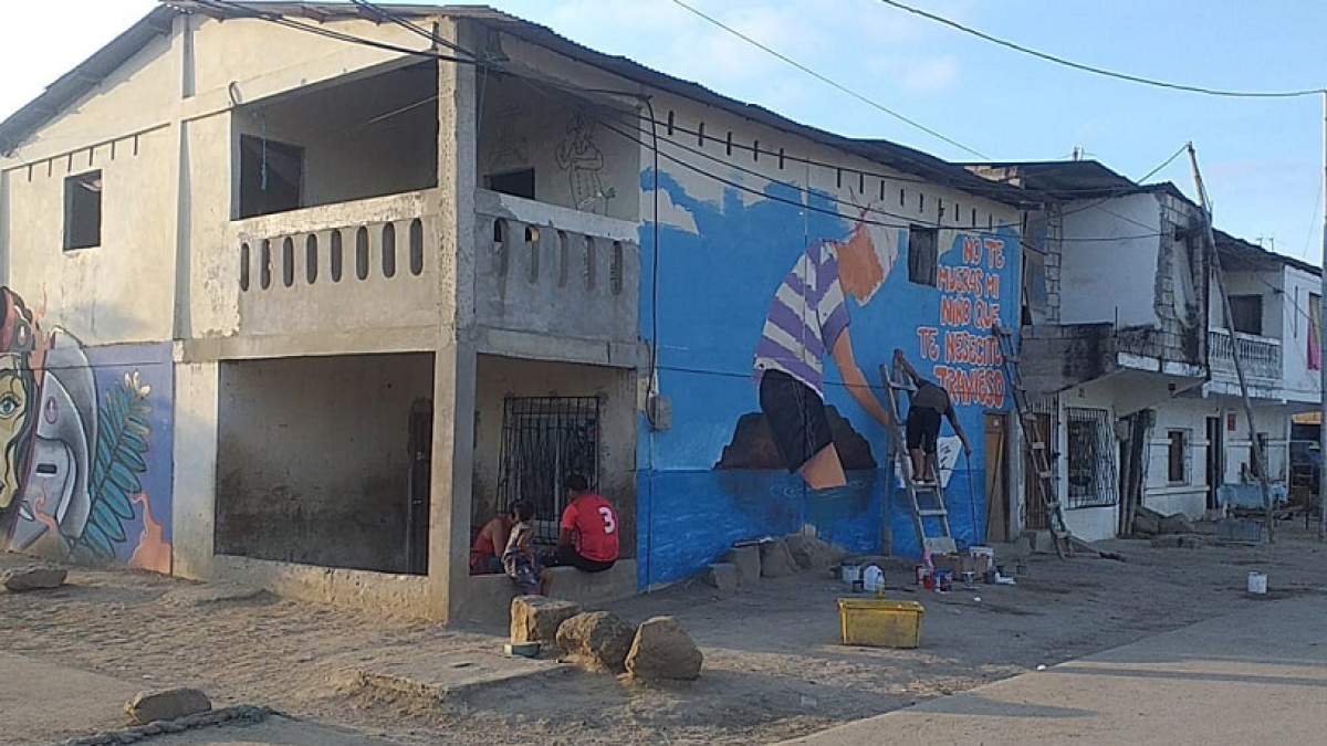 Obras. En la primera pared se muestra la cara de la Valdivia y en la segunda figura, uno de los artistas plasma la figura de un niño, una canoa y el mar.
