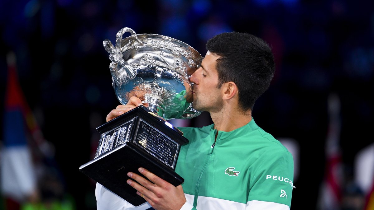 Novak Djokovic besa el trofeo del Abierto de Australia luego de ganarlo por novena vez