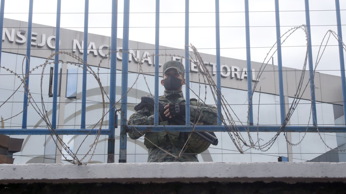Un elemento militar custodio el Consejo Nacional Electoral detrás de una vallado en el perímetro de la institución.