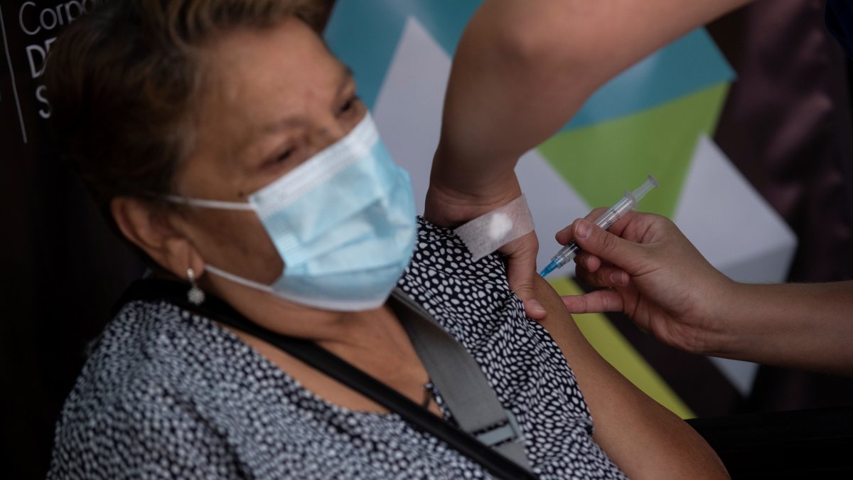 Una enfermera administra una dosis de la vacuna china del laboratorio Sinovac contra la covid-19 a una mujer, hoy en un centro de vacunación en Santiago (Chile).