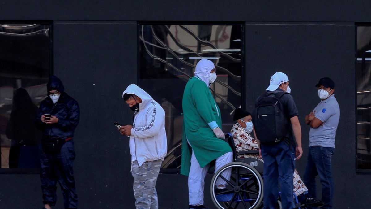 Personal sanitario y familiares de pacientes esperan afuera del hospital Iess del Sur, en Quito (Ecuador).