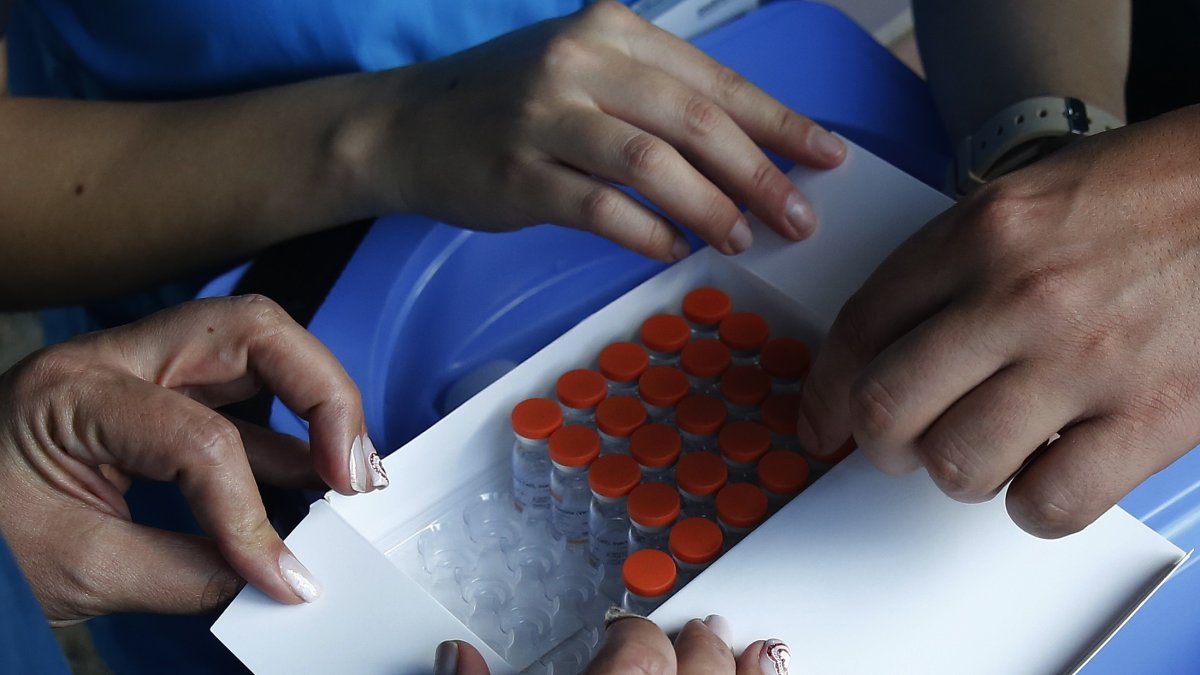 Miembros de la Secretaría de Salud de Medellín entregan dosis de la vacuna de Sinovac contra la covid-19 en un hogar geriátrico.