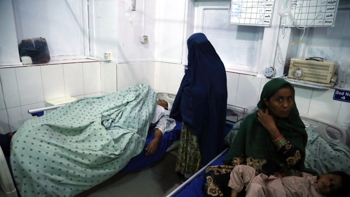 Una mujer recibe atención médica tras resultar herida en uno de los dos asesinatos selectivos perpetrados contra tres presentadoras de televisión afganas que murieron tiroteadas, en Jalalabad.