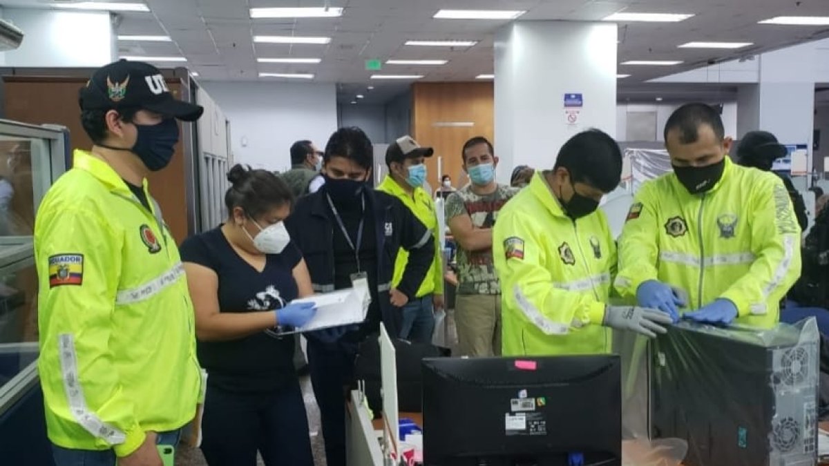 Agentes de la Policía y de la Fiscalía revisan documentos de los sitios allanados en el operativo, esta mañana.