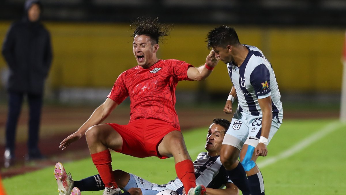 Andrés López (d), de Universidad Católica, disputa un balón con Carlos Ferreira, de Libertad.