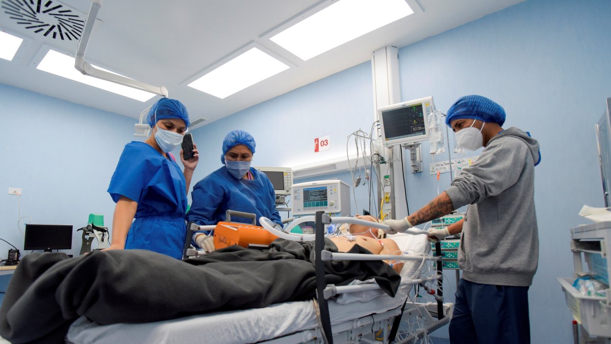 Personal de salud traslada a un paciente fallecido por la Covid-19, el 13 de marzo de 2021, en el Hospital del Instituto Ecuatoriano de Seguridad Social (IESS), en Guayaquil (Ecuador).