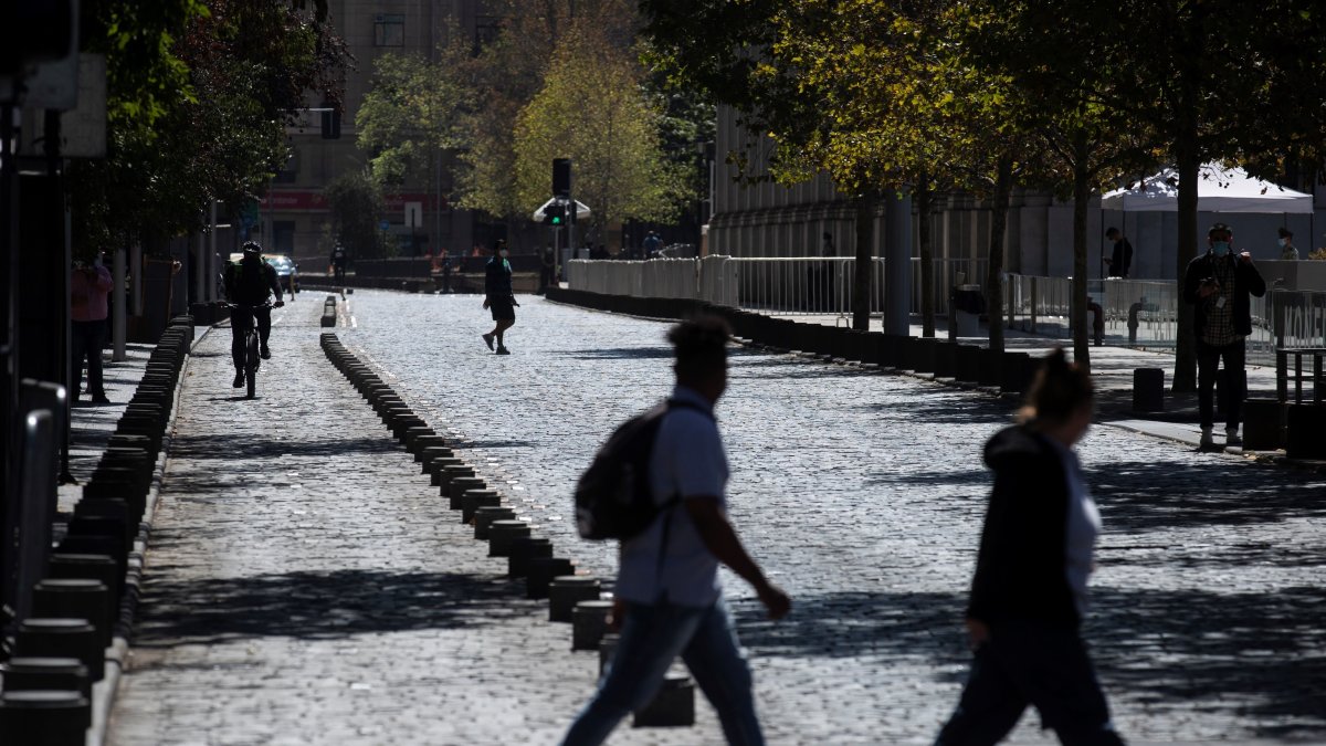 Personas fueron registradas este viernes al cruzar por una calle de Santiago de Chile.