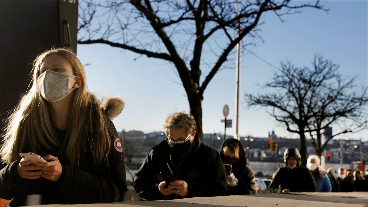 Personas esperan en la fila para recibir las vacunas contra la covid-19 en un sitio de vacunación.