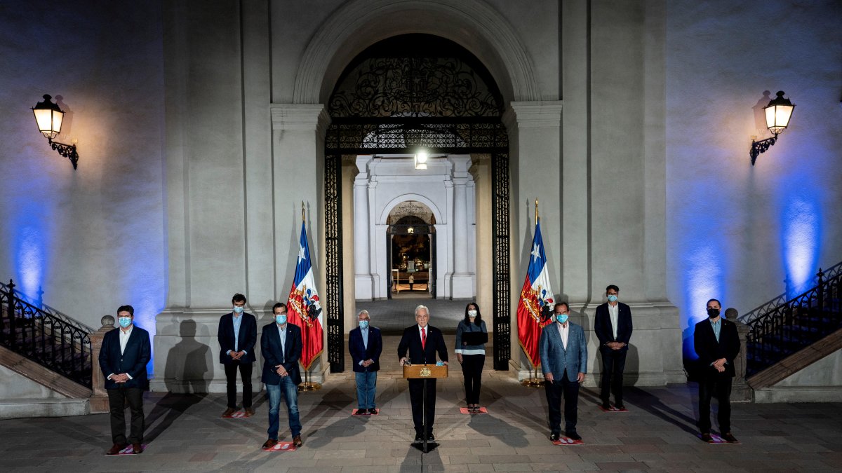 Fotografía cedida este domingo por la Presidencia de Chile en la que se registró al mandatario Sebastián Piñera (c), durante un anuncio público en el que propuso realizar las próximas elecciones el 15 y 16 de mayo.