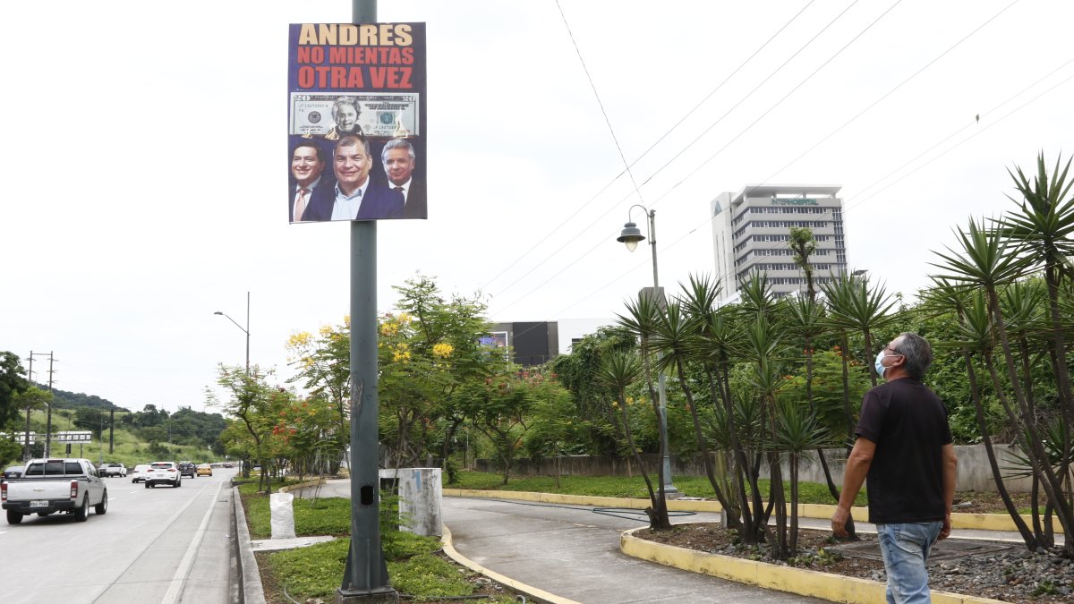 Un ciudadano observa un letrero colgado en la avenida del Bombero, en Guayaquil. Nadie se atribuye su autoría.