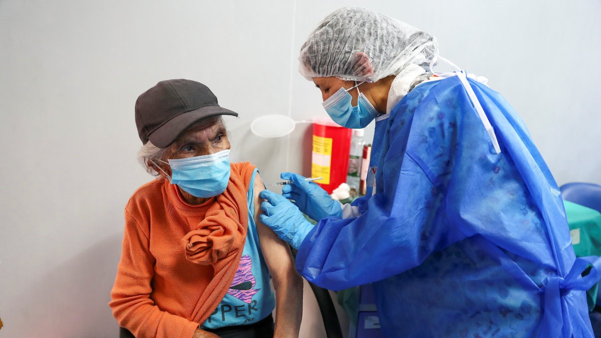 Una adulta mayor es vacunada el 25 de marzo de 2021 contra la covid-19, en el Hospital Luz Elena Arismendi de Quito.