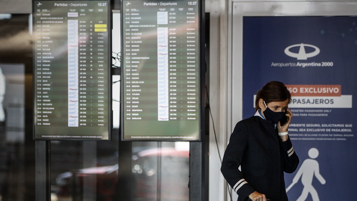 Grupos de personas caminan hoy, por el aeropuerto de Buenos Aires (Argentina).