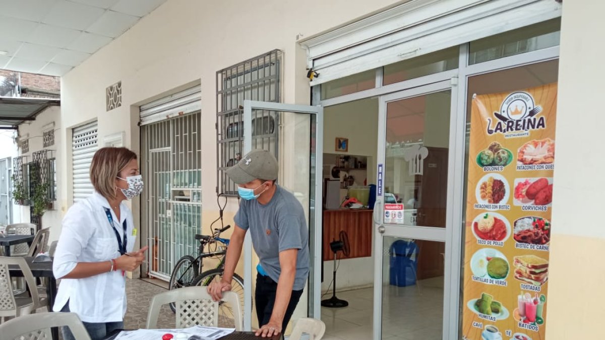 Visita. Funcionaria municipal habla con el administrador de un local.