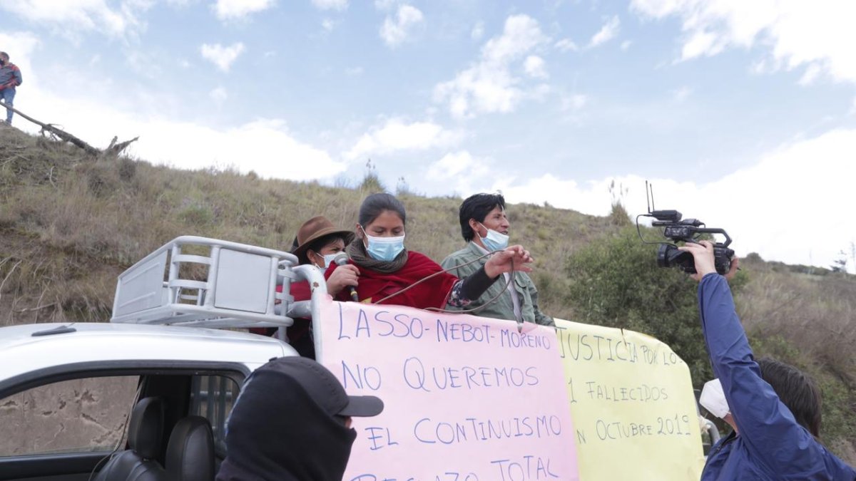 Algunos pobladores rechazan la visita de Guillermo Lasso a Guamote, con carteles en mano.