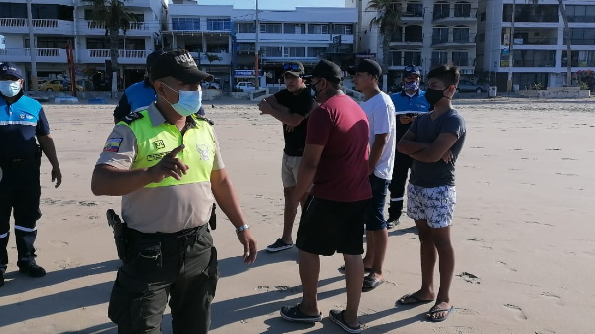 Un agente de Policía dispersa a turistas en la playa de Salinas.