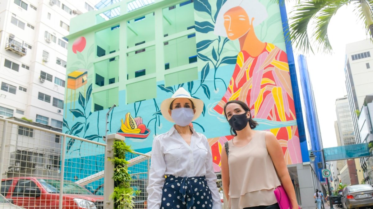 La gerente de la Empresa Pública de Turismo, Gloria Gallardo (i), frente a un mural de la calle Panamá.