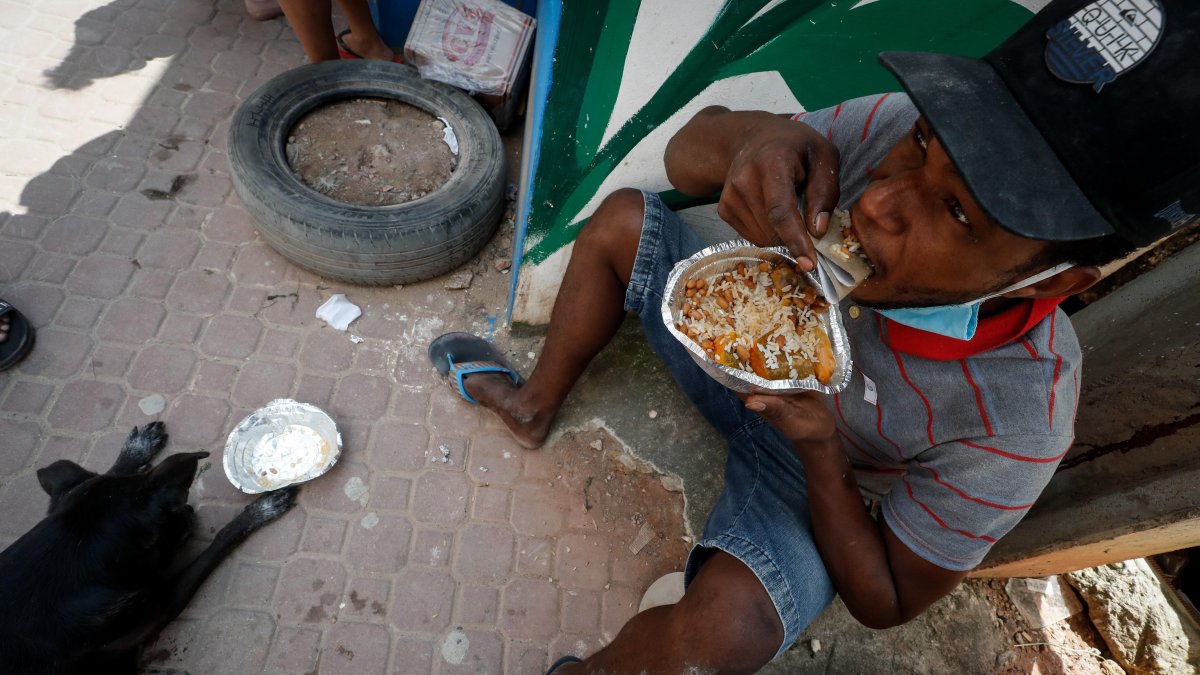 Henrique Silva, de 22 años, almuerza tras recibir una donación de comida en la calle da Paz, el 2 de abril de 2021 en la favela de Paraisópolis, en Sao Paulo (Brasil).