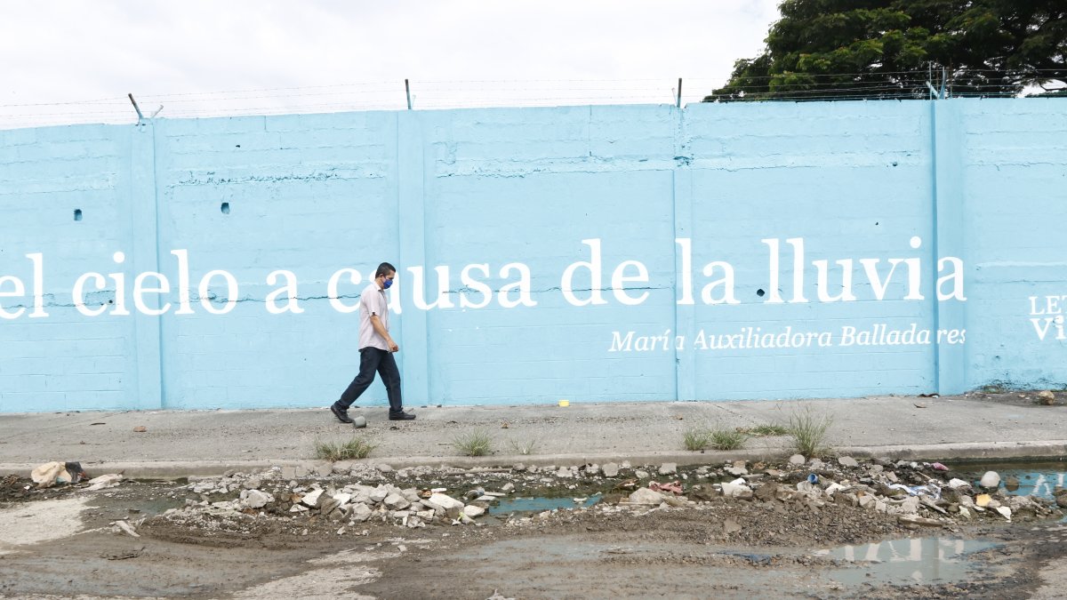 Un aspecto del suburbio muestra el costoso proyecto Letras Vivas junto a un bache.