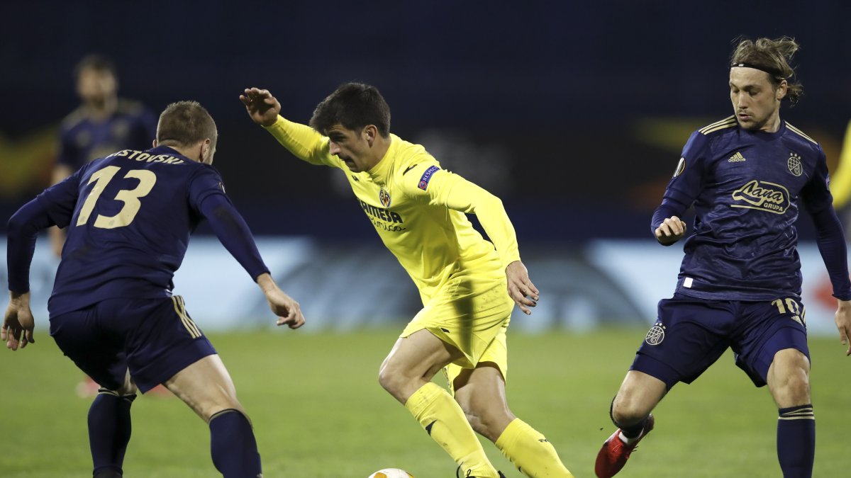 Gerard Moreno (centro) del Villarreal protege el balón ante la marca de Stefan Ristovski (izquierada)