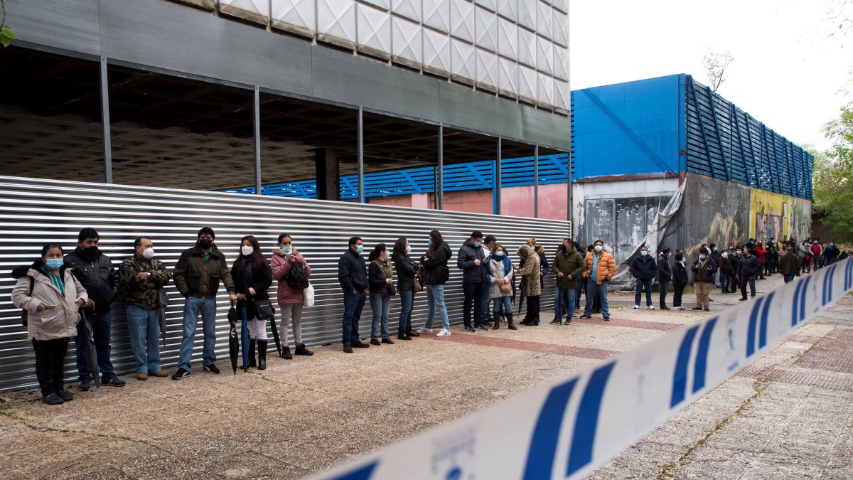 Varios votantes ecuatorianos esperan su tuno para participar en la segunda vuelta de las Elecciones 2021 este domingo, en el Pabellón de Cristal de la Casa de Campo de Madrid.