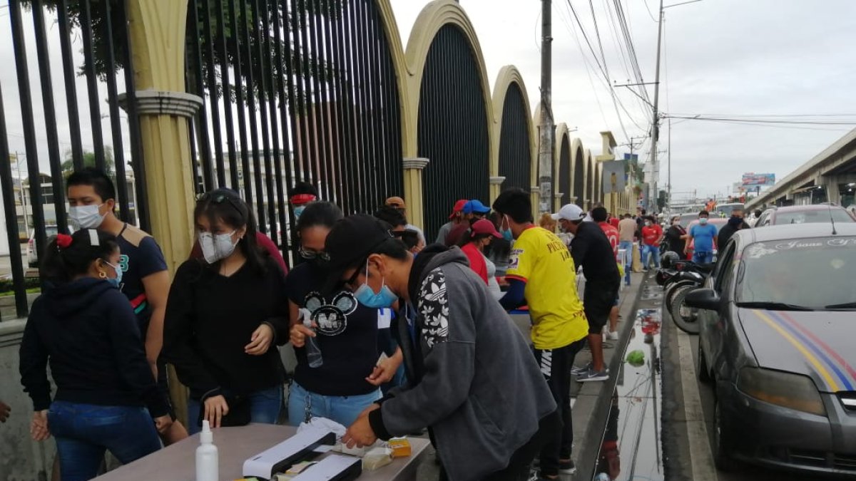 En la medida que llegan más ciudadanos a votar se forman los grupos que buscan plastificar la cédula de votación.