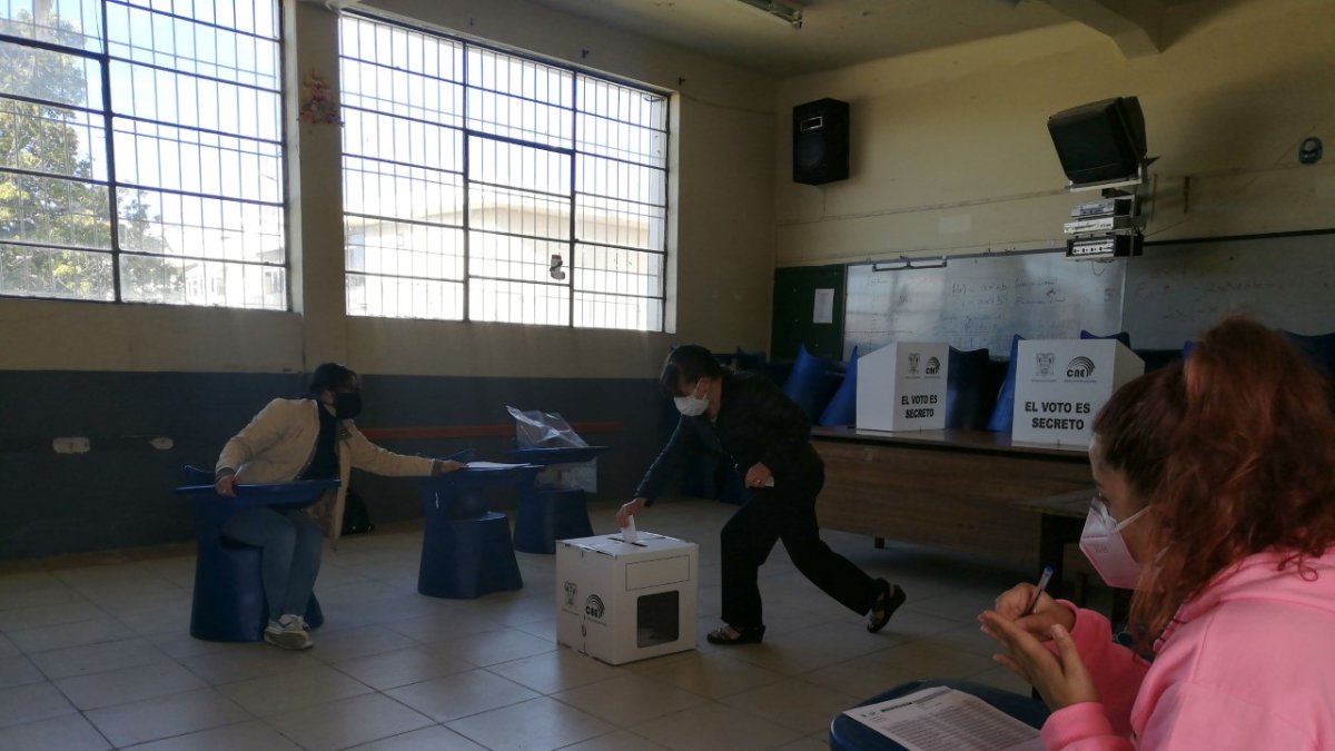 Una persona de la tercera edad deposita su voto. Las elecciones se desarrollan sin contratiempos en Cuenca.