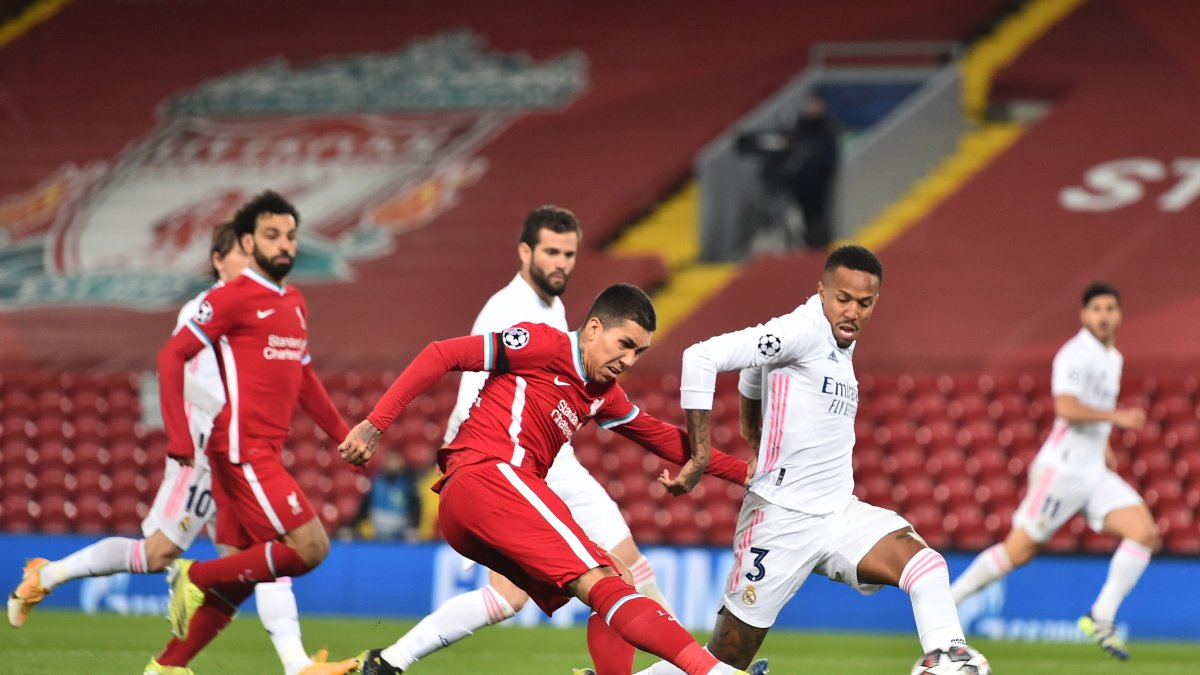 Firmino, del Liverpool, intenta rematar ante la marca del madridista, Militao.