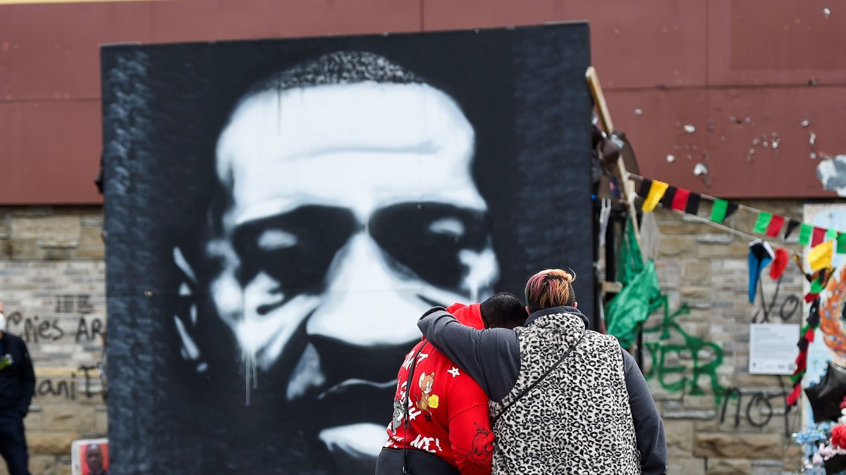 Una pareja frente a un retrato de George Floyd este 20 de abril de 2021 en Minéapolis.
