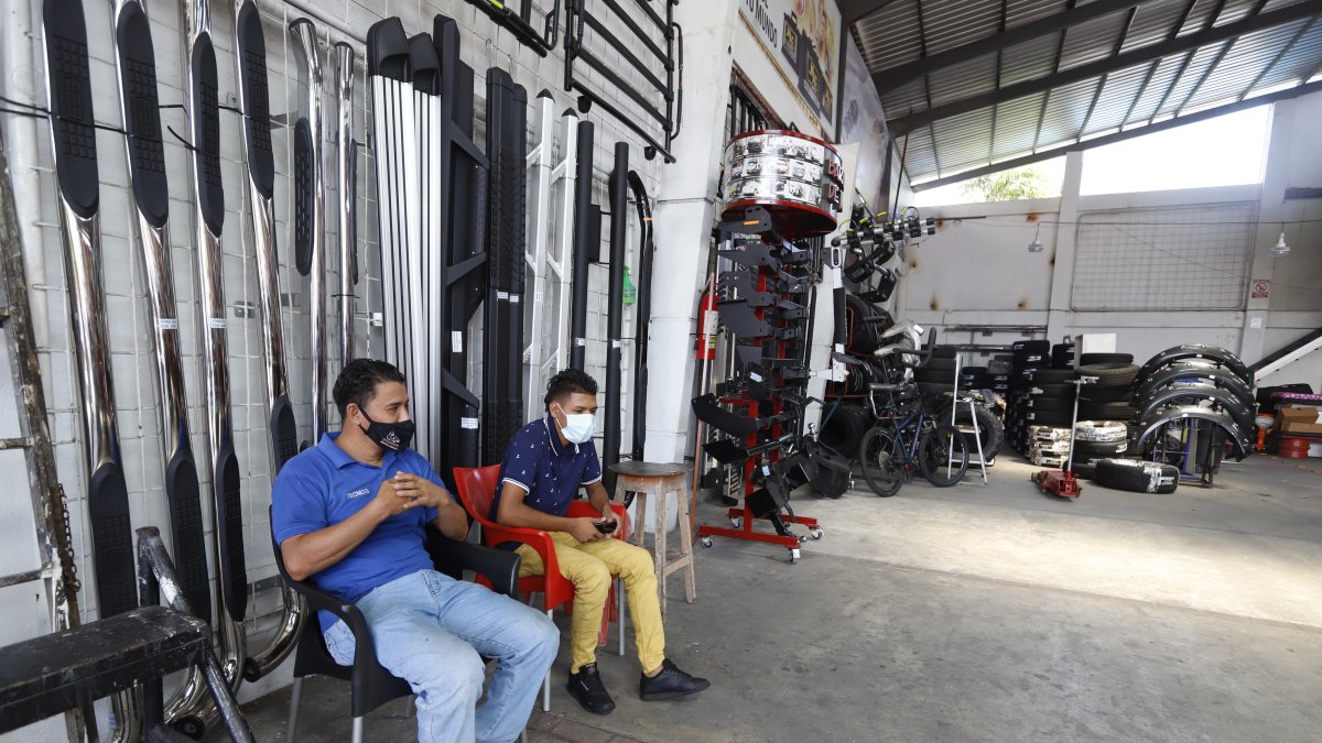 Trabajadores de una tienda de accesorios a la espera de clientela, en el centro de Guayaquil.