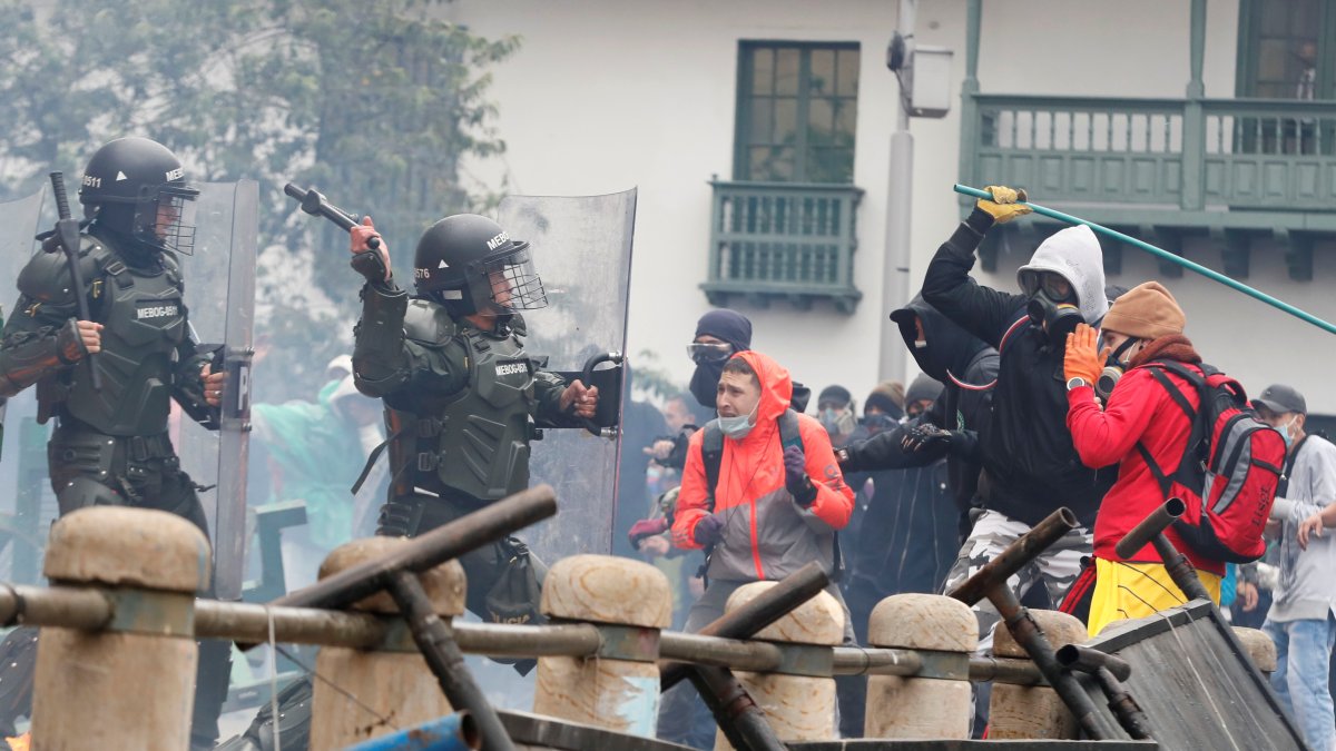 Manifestantes se enfrentan con agentes de Policía durante una protesta el 28 de abril de 2021, en la Plaza de Bolívar de Bogotá.
