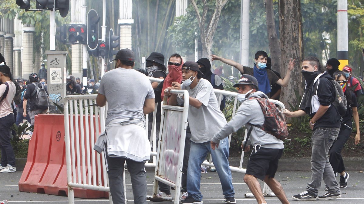 Manifestantes se enfrentan a las autoridades en las protestas contra la reforma tributaria convocadas por las centrales obreras, hoy en Medellín (Colombia). 