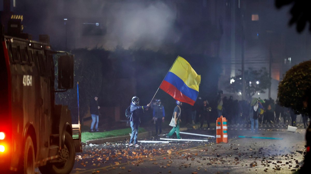 Imagen 1 de mayo. Integrantes del Escuadrón Móvil Antidisturbios (ESMAD) se enfrentan a manifestantes que llegan al barrio donde tiene su residencia el presidente de Colombia Iván Duque.