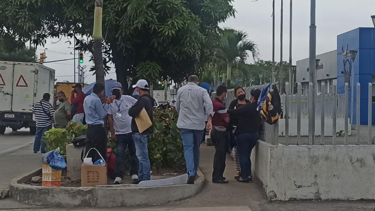 Familiares de la víctima permanecen fuera de la morgue a la espera de que les entreguen su cuerpo.