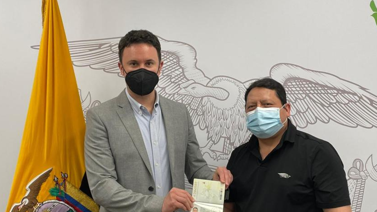 El diplomático del consulado ecuatoriano, Carlos Martínez Bolaños, entrega el documento a Juan Gabriel Sibri,