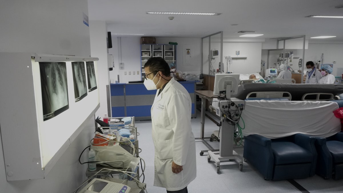 El doctor Juan Carlos Aveiga, director médico del hospital Alcívar de Guayaquil, revisa la historia médica de un paciente dentro de la unidad de cuidados intensivos no COVID.