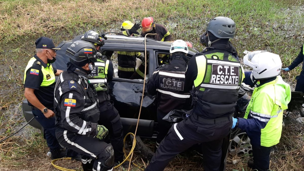 Agentes de la CTE y bomberos auxilian a los pasajeros de un carro que se accidentó en la vía Durán - Yaguachi.