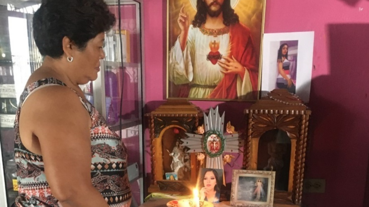 Nube Dolores mantiene todo el día una vela encendida por su hija Johanna Tapia. Su foto está en medio de varias imágenes de santos.