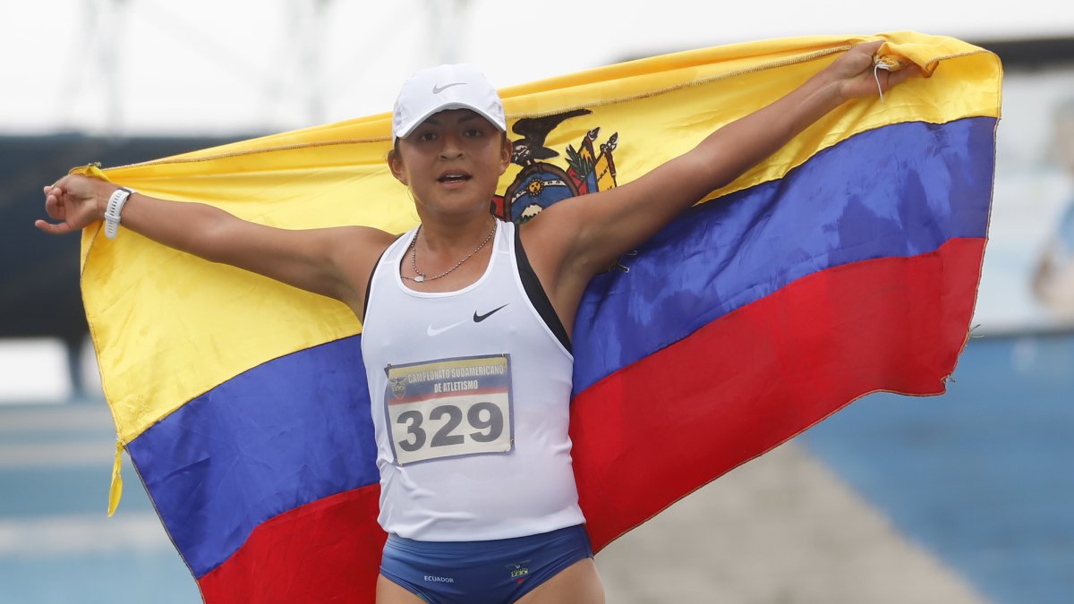 Glenda Morejón, marchista ecuatoriana,  muestra la bandera nacional tras lograr la medalla de oro.