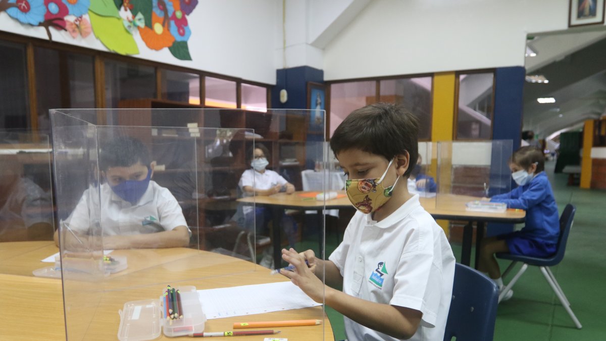 Desde sus pupitres a dos metros de distancia y separados por mamparas, los alumnos del Balandra Cruz del Sur cruzan miradas entre ellos.