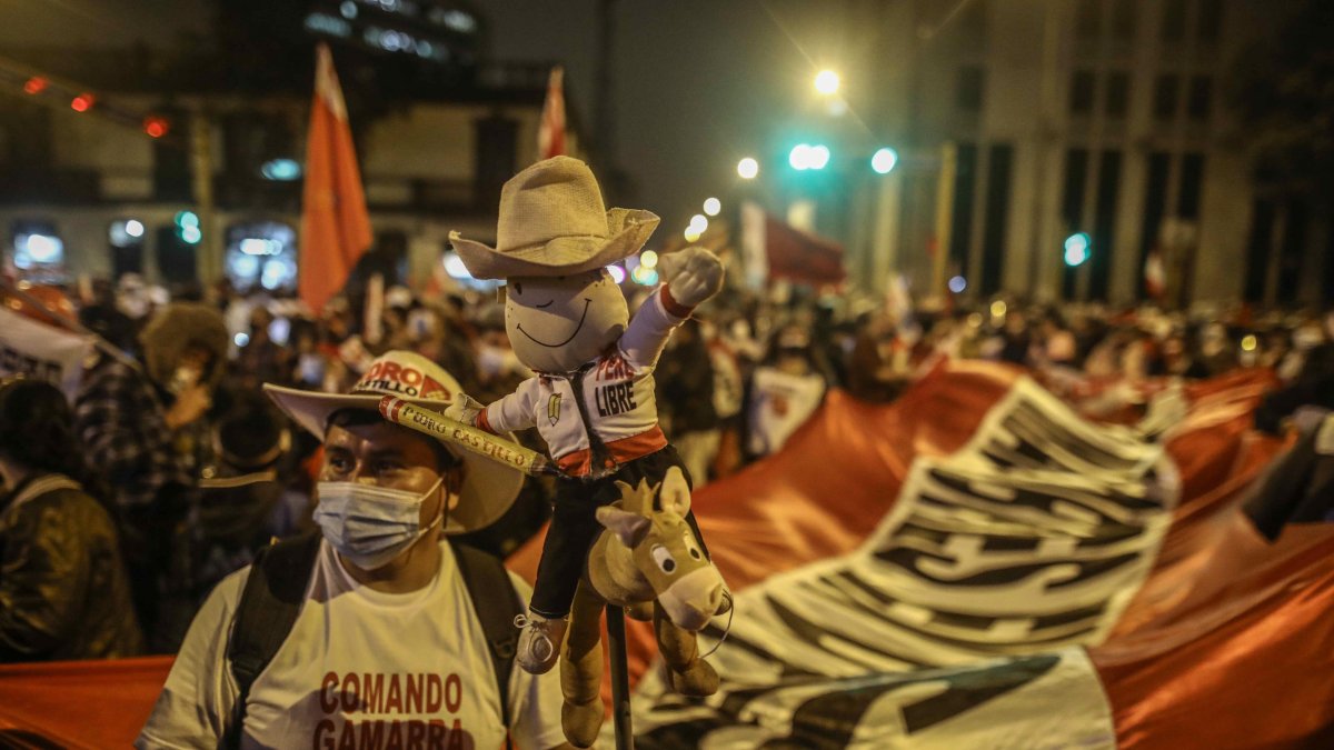Simpatizantes de Pedro Castillo esperan los resultados electorales hoy, frente a su local central de campaña en Lima (Perú).
