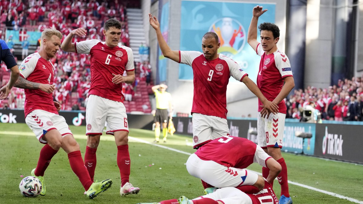 Los jugadores de Dinamarca piden que los médicos entren en el terreno de juego después de que su compañero de equipo Christian Eriksen se desplomara durante el partido de fútbol.