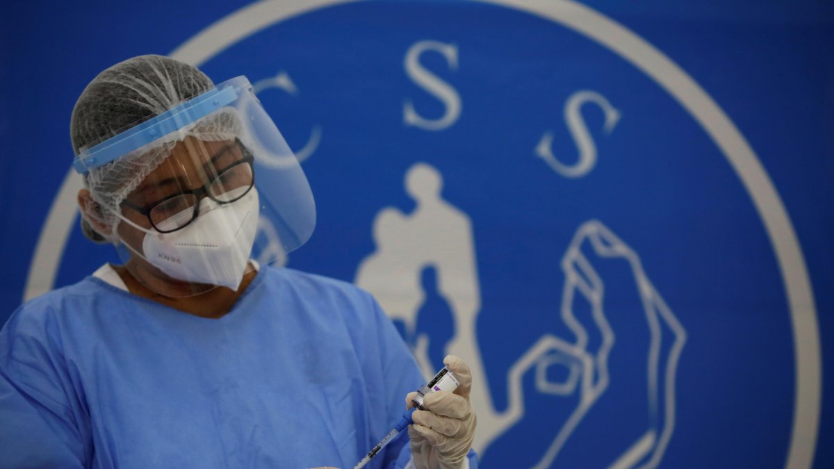 Personal médico de la Caja del Seguro Social de Panamá (CSS), prepara una primera dosis de AstraZeneca.