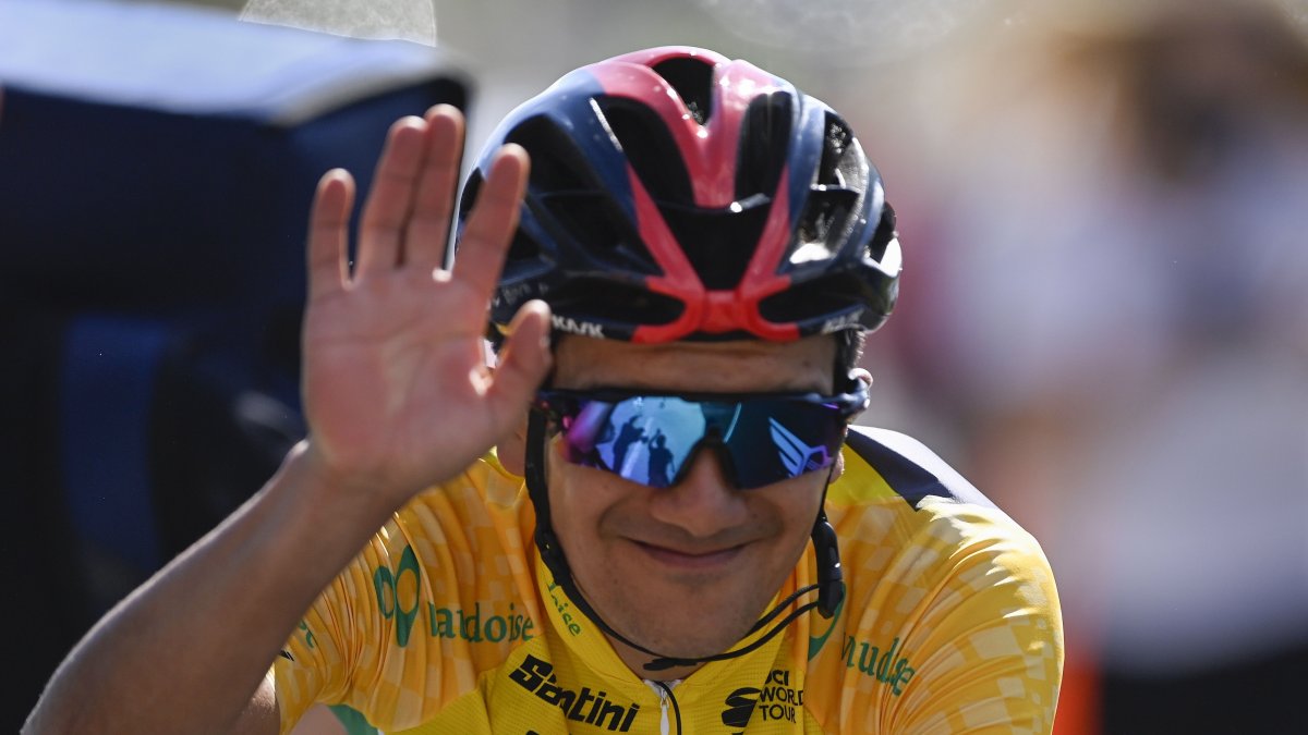 El ciclista ecuatoriano Richard Carapaz, del Ineos, saluda tras cruzar la meta como líder de la clasificación general.