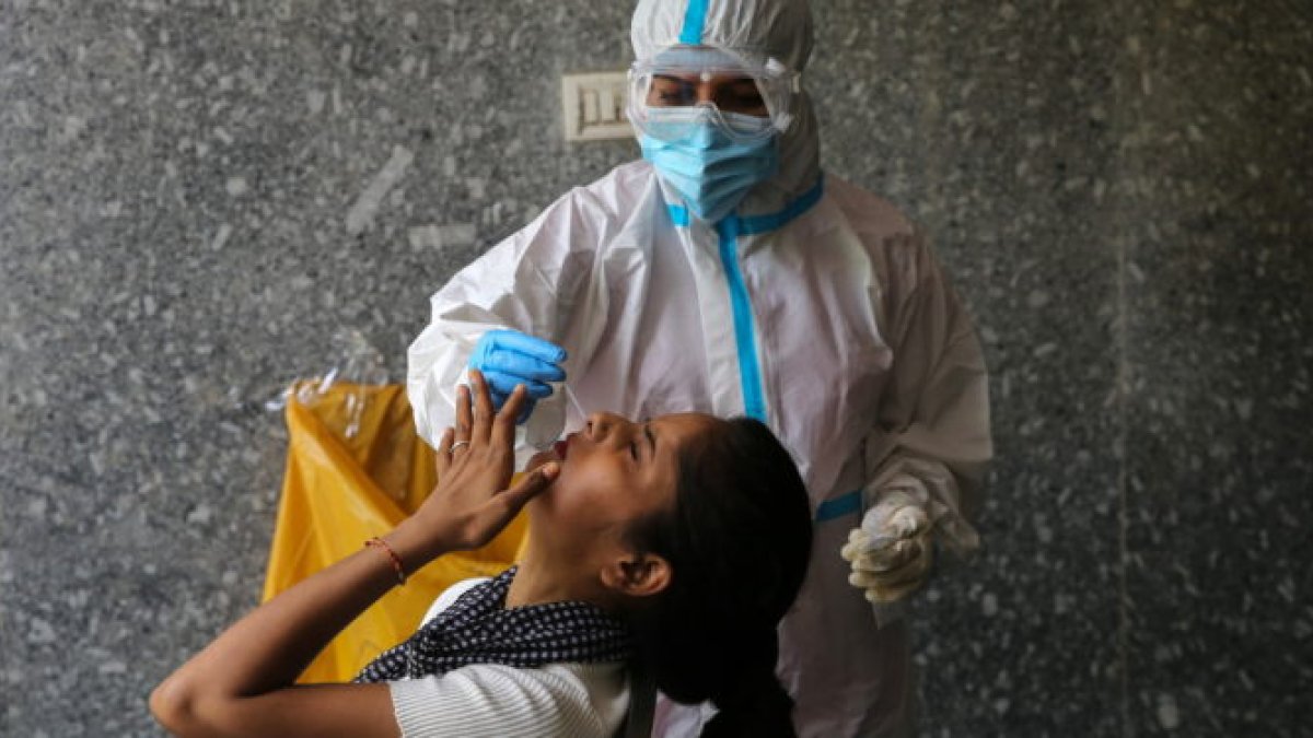 Un médico recoge muestras de las fosas nasale de una ciudadana en Nueva Delhi.