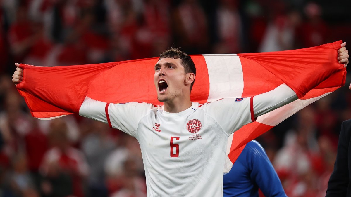 Andres Christensen muestra una bandera danesa luego de la victoria frente a Rusia.
