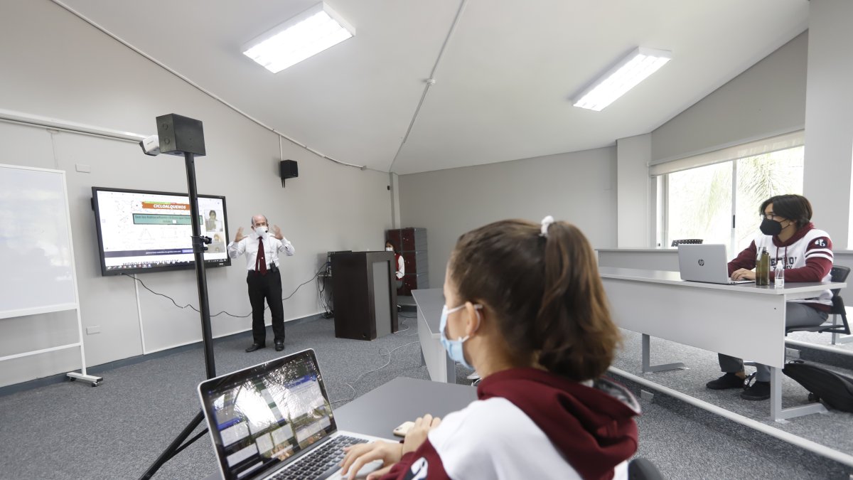 En la Unidad Educativa La Moderna el profesor transmite la clase que está dando en el aula para los estudiantes que están en  casa.