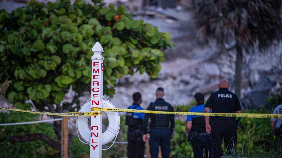 Agentes de la Policía custodian los alrededores del edificio de 12 pisos parcialmente colapsado.