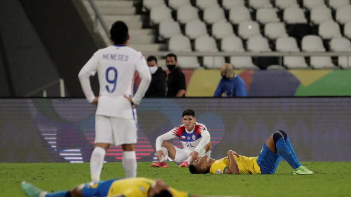 Jugadores de Brasil y Chile descansan tras el final de un partido por los cuartos de final de la Copa América en el estadio Nilton Santos de Río de Janeiro (Brasil).