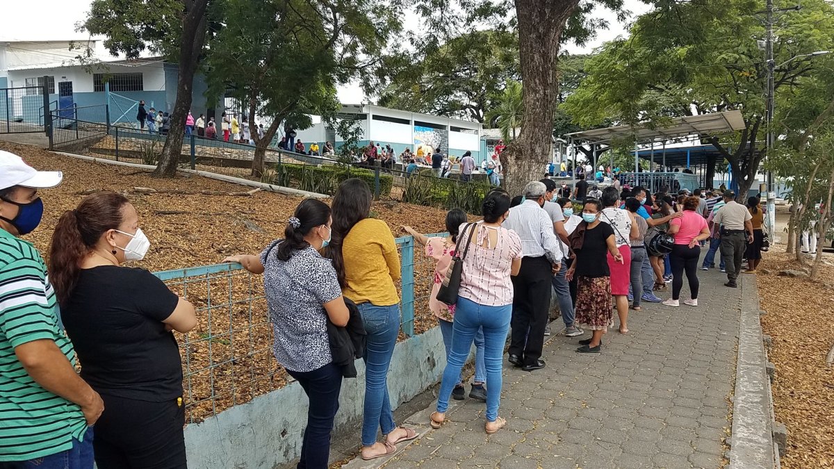 Decenas de personas forman una larga columna para recibir la vacuna en la Academia Naval Illinngworth,en el norte de Guayaquil, el jueves 8 de julio.